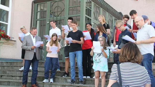 Schüler der Dillenbergschule tragen ihren Song über die Cadolzburg auf der Rathaustreppe vor